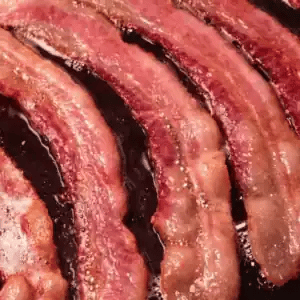 Close-up of sliced bacon with a dark background